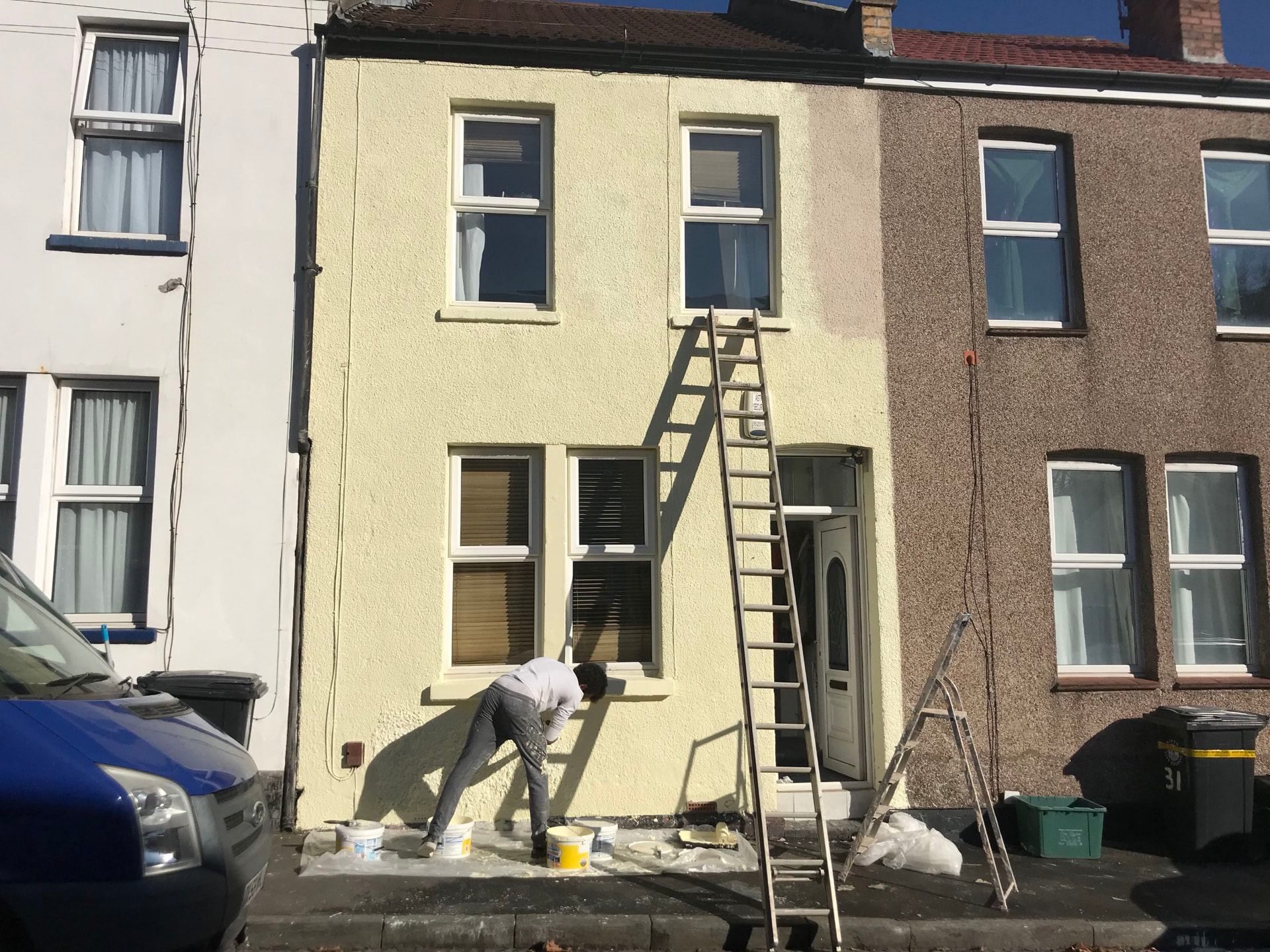 Exterior house being painted on a sunny day